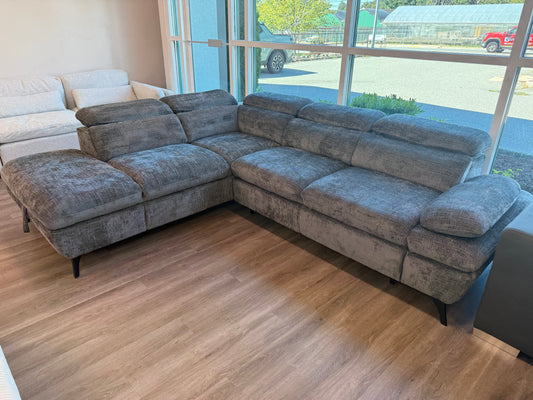 Gray sectional sofa bed  in a room with large windows 