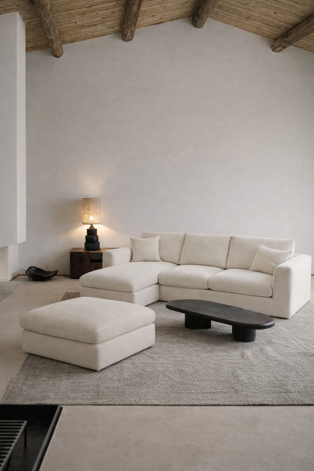 Modern living room with a white sectional sofa, ottoman, and coffee table.